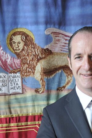 1280px-Luca_Zaia_con_bandiera_della_Regione_del_Veneto